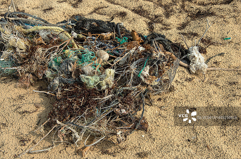 墨西哥坎昆女人海岸海滩上缠绕的尼龙绳、其他渔具和休闲船只的废弃物以及海藻图片素材