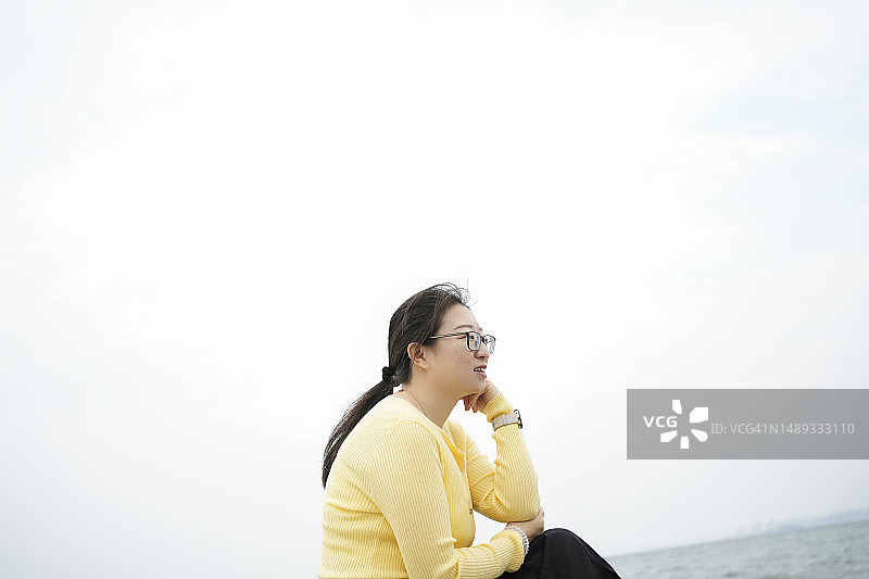 女人坐在海边听着海浪声图片素材