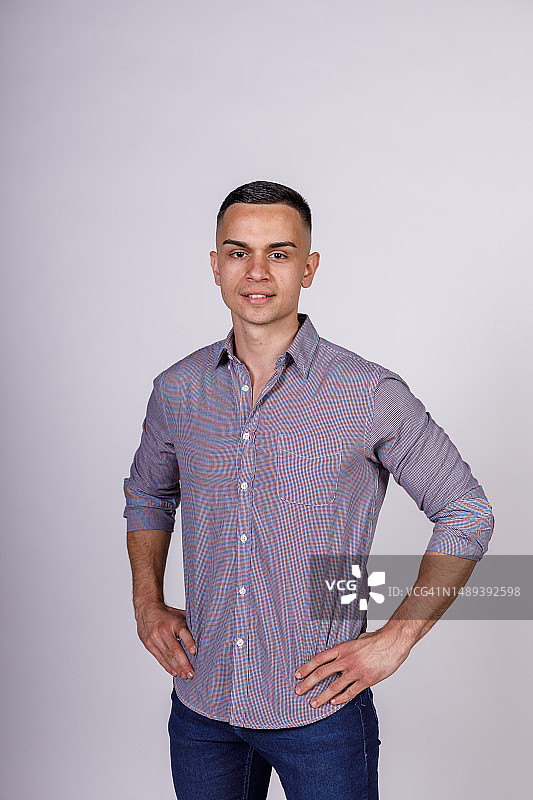 站在白色背景前微笑的自信年轻人图片素材