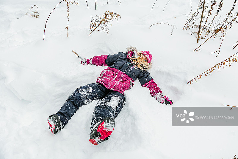 冬天，疲惫的女孩躺在雪地里图片素材