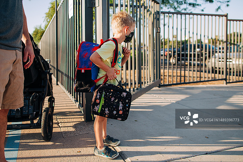 疫情期间，一个六岁的蒙面男孩开始上幼儿园图片素材