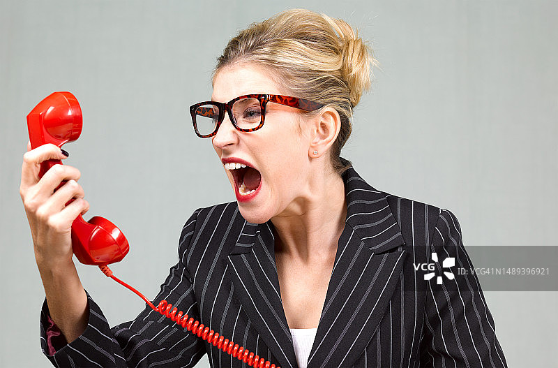 愤怒的女人对着电话大喊大叫图片素材
