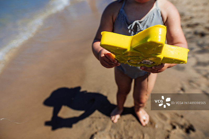 在海滩上拿着沙滩玩具的女孩图片素材