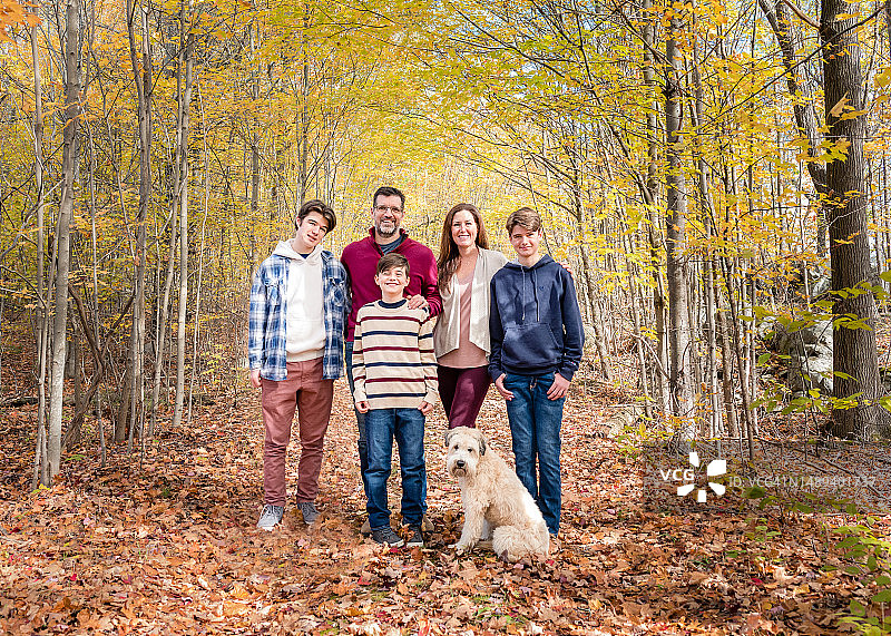秋日里一家五口在树林外的肖像图片素材
