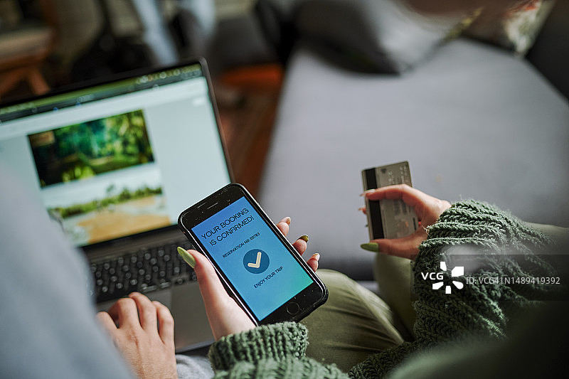 女性持信用卡和手机在线预订度假特写图片素材