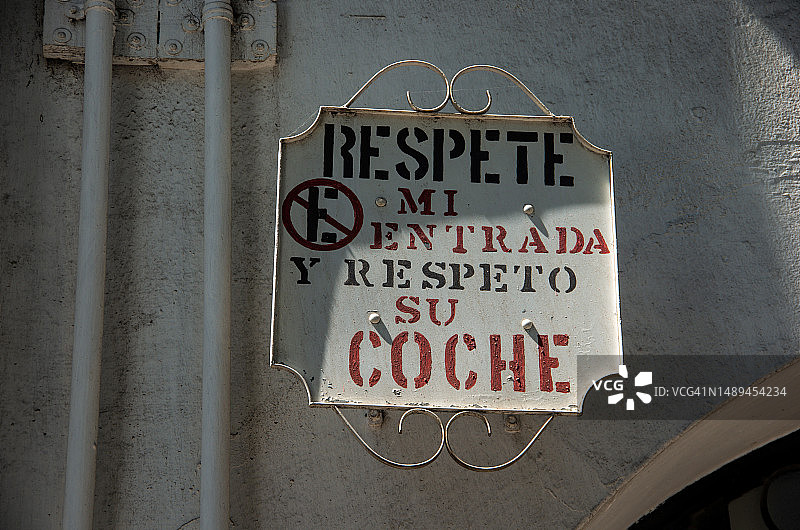 殖民风格住宅楼上的西班牙语禁止停车标志：请尊重我的入口，我尊重你的车图片素材