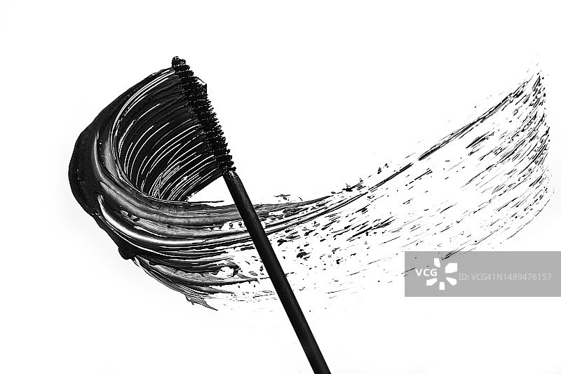 黑色眼线膏从睫毛膏刷在白色背景上，呈波浪状涂抹，分离。用于睫毛的化妆品。图片素材