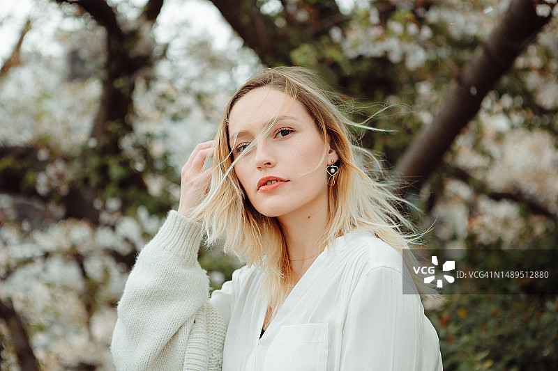 在日本樱花树下的年轻金发女人图片素材