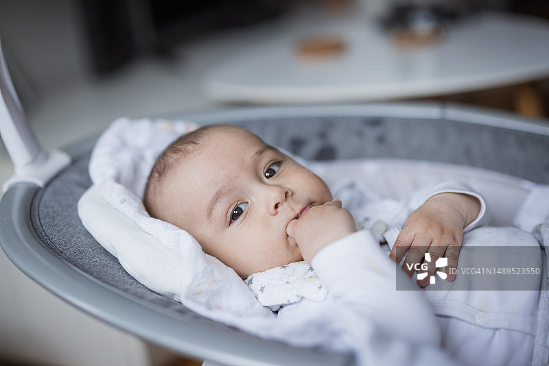 婴儿躺在婴儿摇椅上休息图片素材