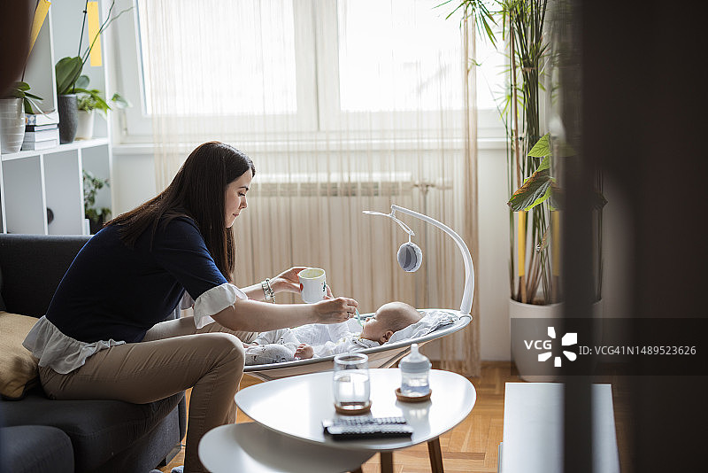 快乐的母亲给宝宝喂健康的食物图片素材
