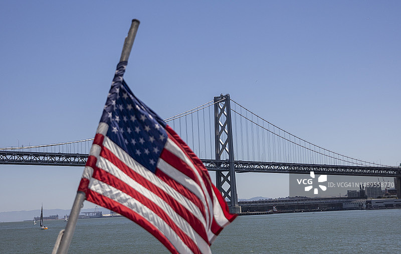 在旧金山-奥克兰海湾大桥前的美国国旗图片素材