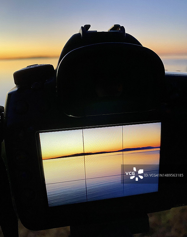拍摄日出，相机背面的数字图像图片素材