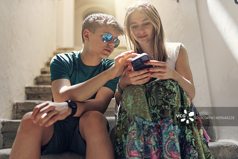 坐在楼梯上使用手机的Z世代青少年图片素材