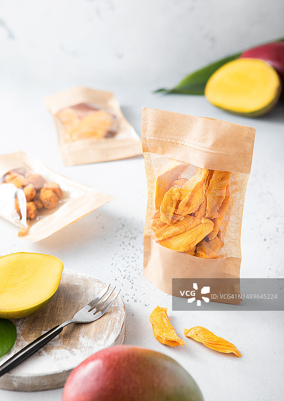 浅色背景上的各种甜芒果干和芒果球包装图片素材