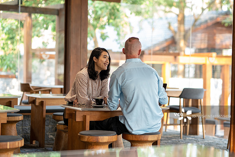 咖啡馆社交：亚洲女性与朋友喝咖啡放松图片素材
