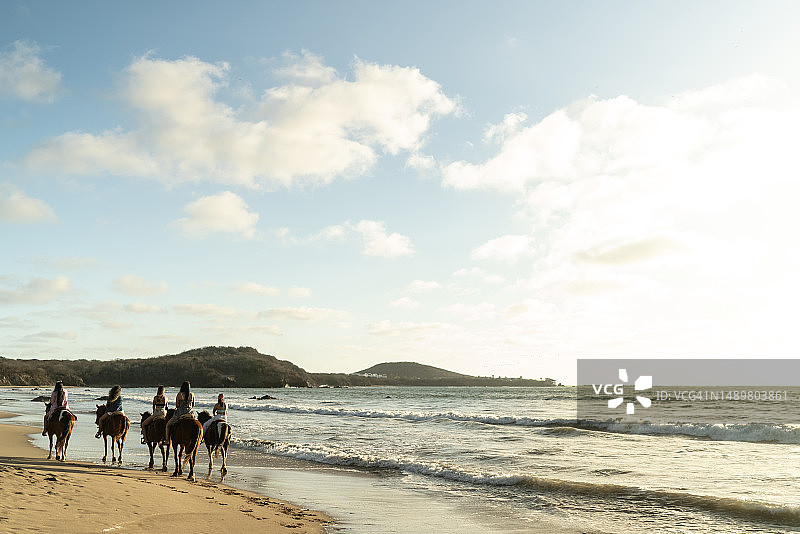 女朋友们在海滩上骑马图片素材