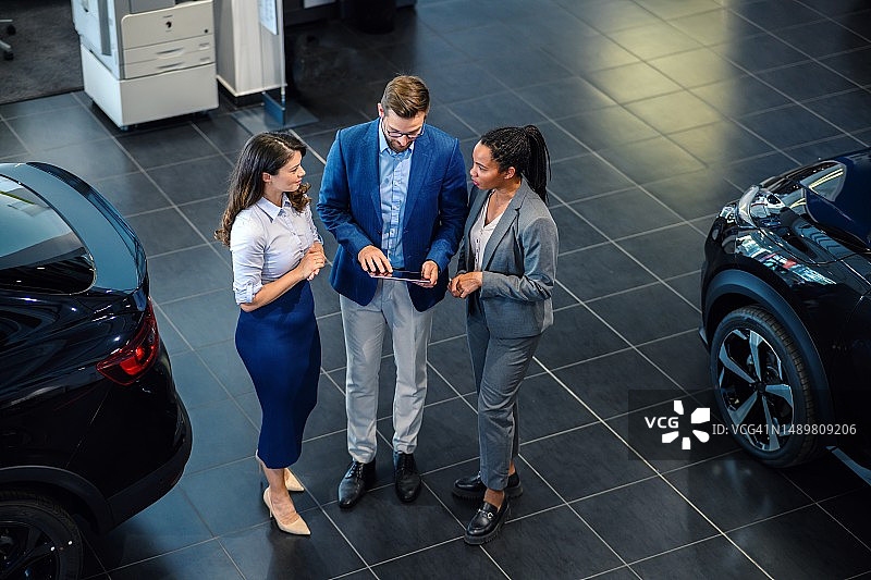 在汽车展厅里交谈的快乐商界人士的俯视图图片素材