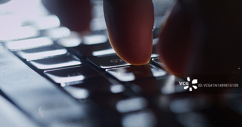 在笔记本电脑键盘上输入电子邮件的手部特写图片素材