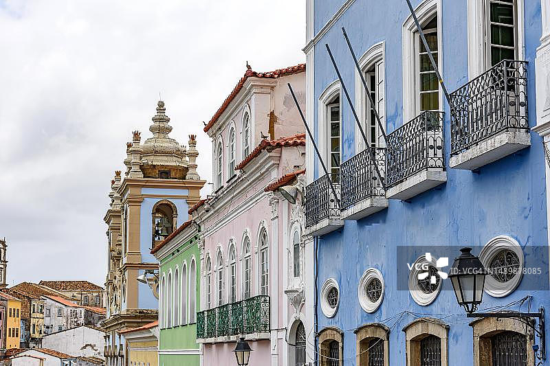 巴西巴伊亚州萨尔瓦多市佩洛乌里尼奥历史区的老式彩色殖民风格房屋和教堂外墙图片素材