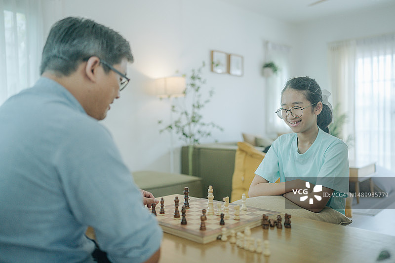 专心和女儿下棋的亚洲老年人图片素材