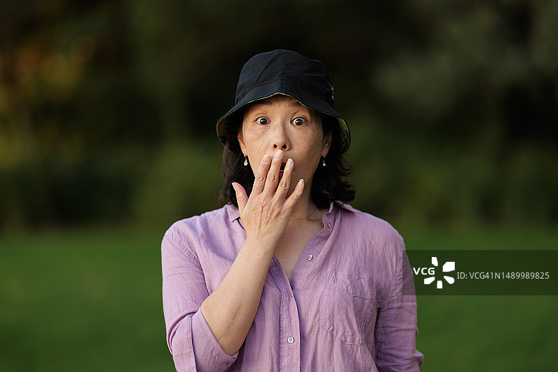 戴着帽子、表情惊讶的户外亚洲女性图片素材