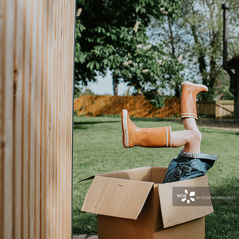 孩子在花园玩纸箱图片素材