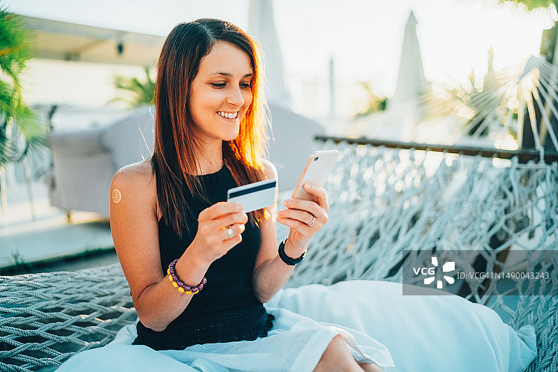 在吊床上网购的女人图片素材