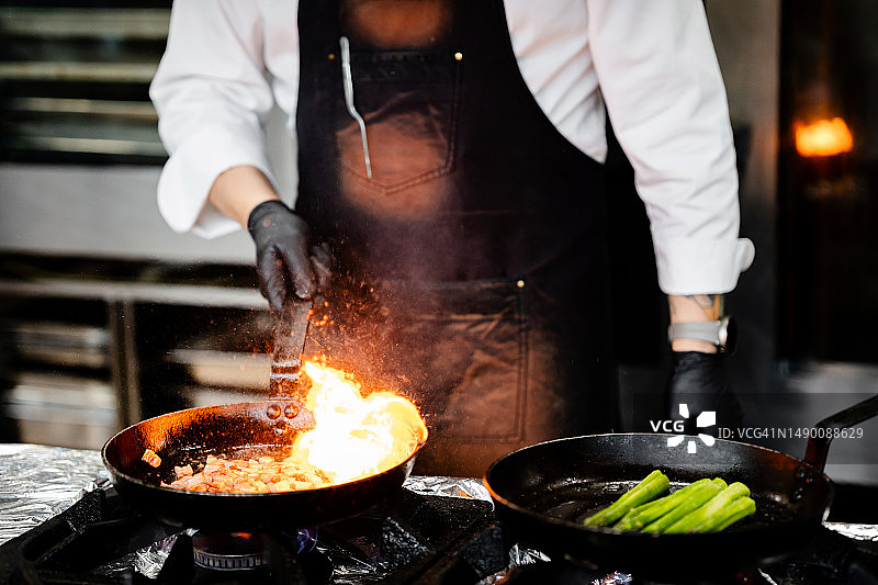 专业厨师在商业厨房中烹饪美食图片素材