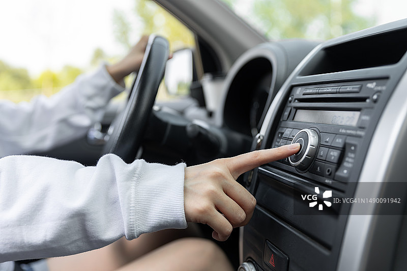 女子在车内转动收音机的按钮图片素材