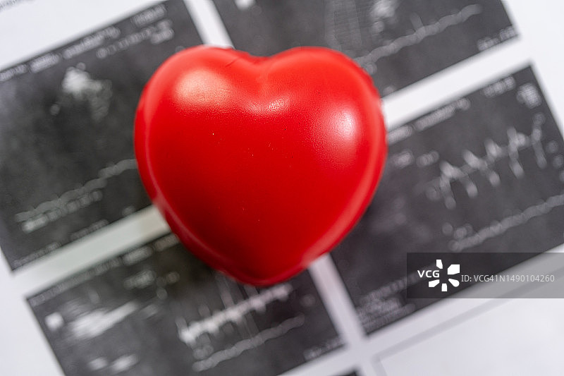 心脏病患者心电图报告上的红色爱心，心脏病学与医疗概念图片素材