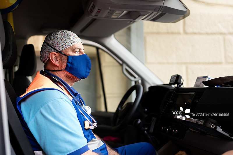 神情专注的医生坐在救护车里，直视前方图片素材