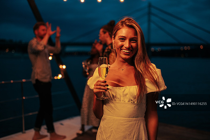 在船上端着酒杯的迷人时尚女性图片素材