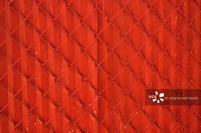 涂有鲜艳红色的波纹铁衬背的铁丝网图片素材
