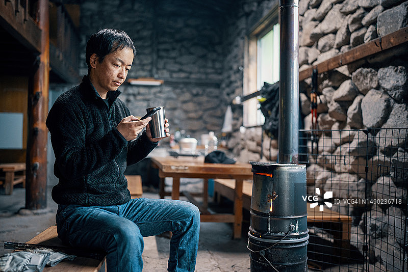 中年男人在度假屋里用智能手机查看财务状况图片素材