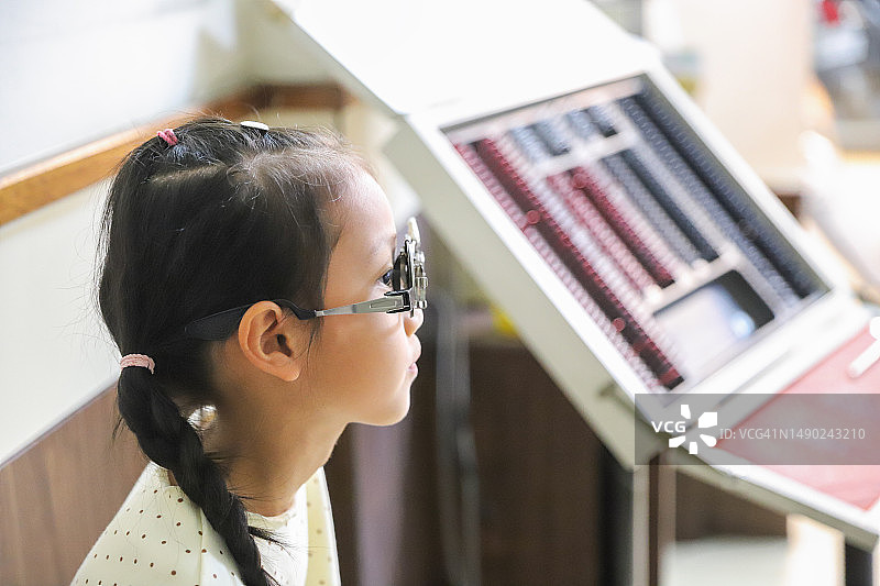 亚洲女孩在诊所做视力检查图片素材