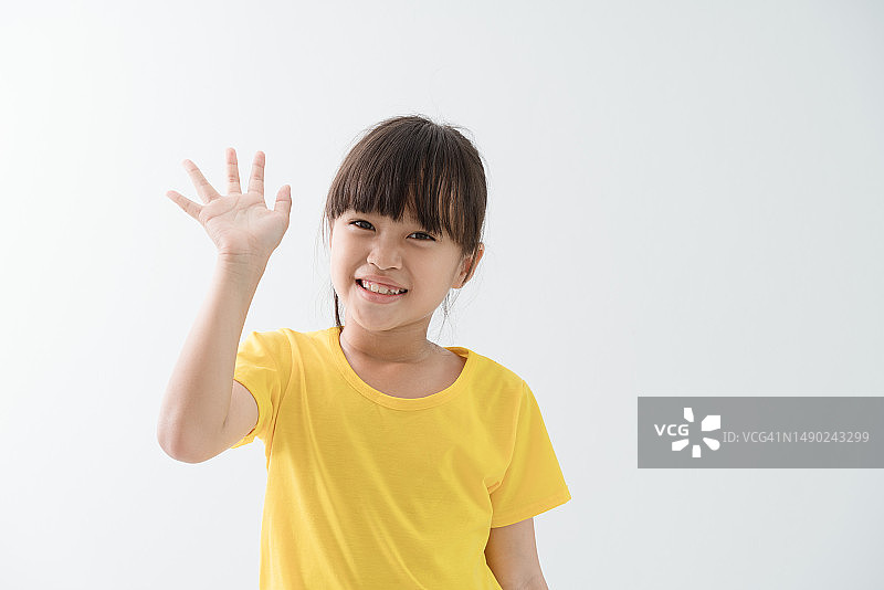 向你挥手问好并微笑的快乐女孩图片素材