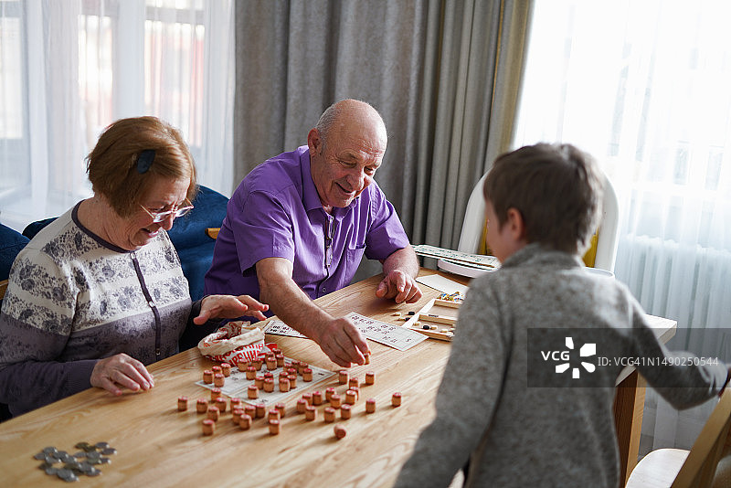 爷爷奶奶孙子春日傍晚在厨房玩桌游图片素材