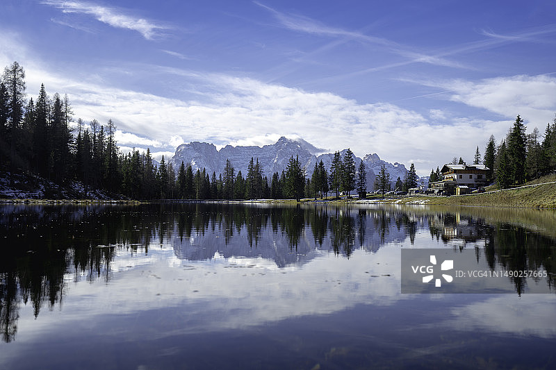 安托诺湖上树木的全景天空倒影湖有住宿和许多旅游车。晴朗的天空背景是意大利米苏里纳附近的萨拉菲山脉。图片素材