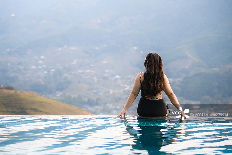 穿着泳衣欣赏风景的休闲女孩图片素材