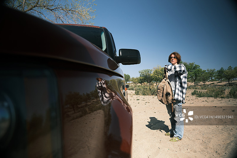 女子站在海滩上的汽车旁图片素材