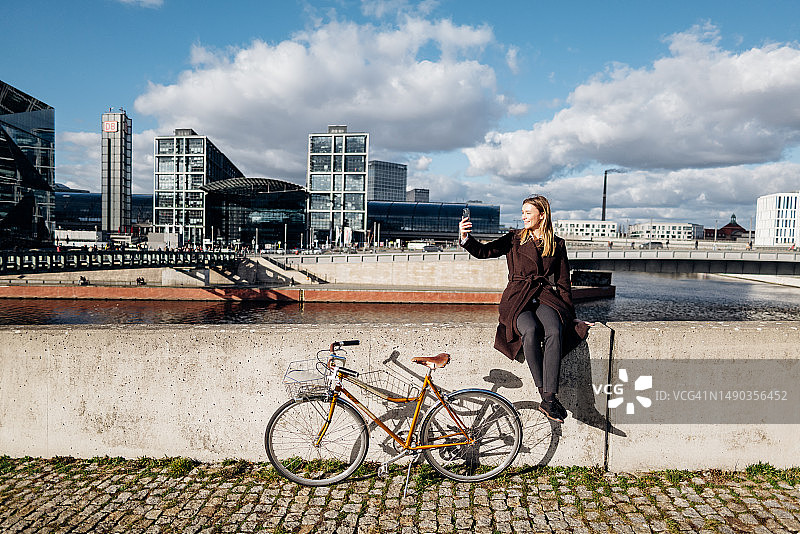 女商人坐在墙上，骑车视频通话图片素材