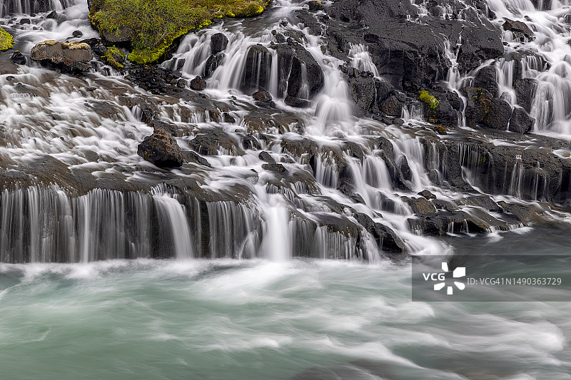 Hraunfossar是冰岛独特的瀑布，水流在罗马尼亚的熔岩石下图片素材