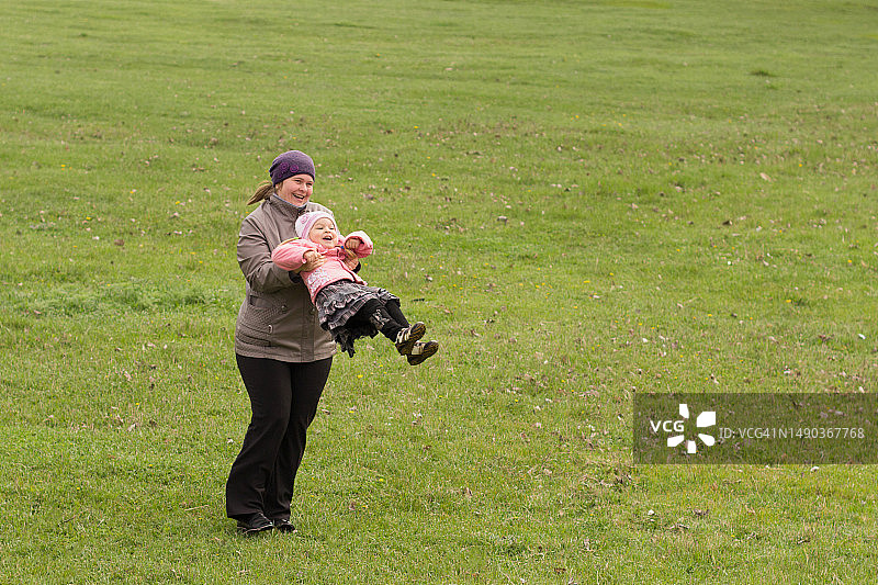 在乌克兰的草地上，女子抱着女婴站立图片素材