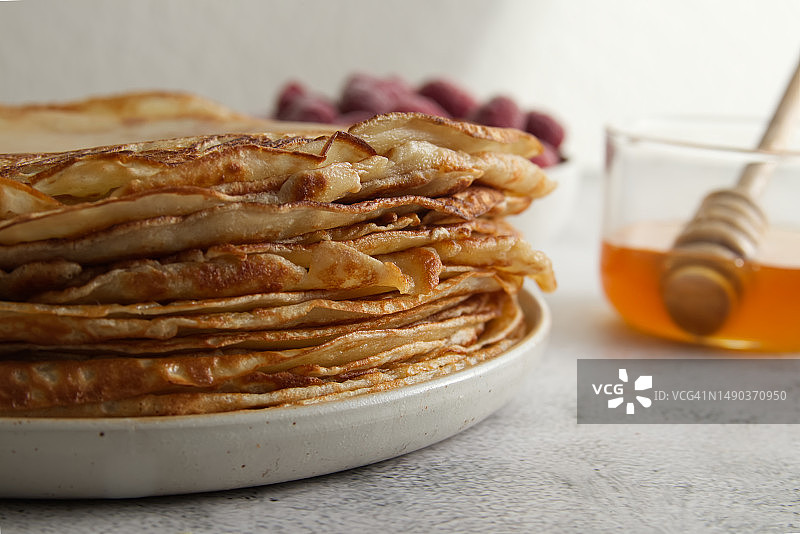 桌子上叠放的蜂蜜覆盆子可丽饼，德国柏林图片素材