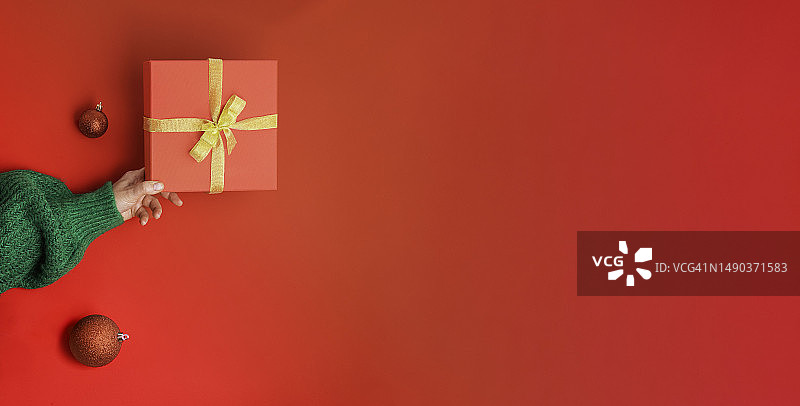 女人手圣诞红色礼盒金色蝴蝶结图片素材