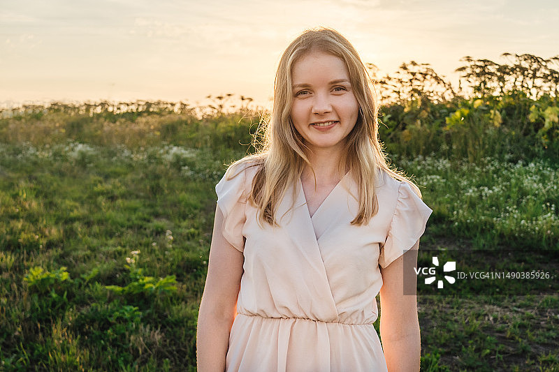 身穿连衣裙的女人站在田野里，俄罗斯彼尔姆边疆区图片素材