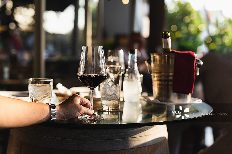 在餐厅户外餐桌上手持红酒杯图片素材