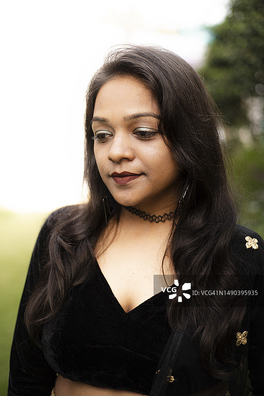 在印度古吉拉特邦万卡尔的田野里向远处看的年轻女人图片素材