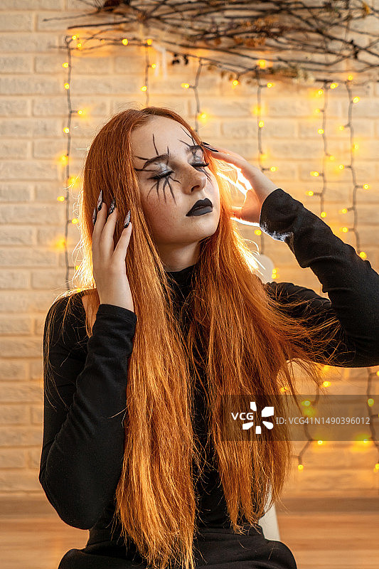 年轻女人脸上涂着油彩，站在墙边，俄罗斯图片素材