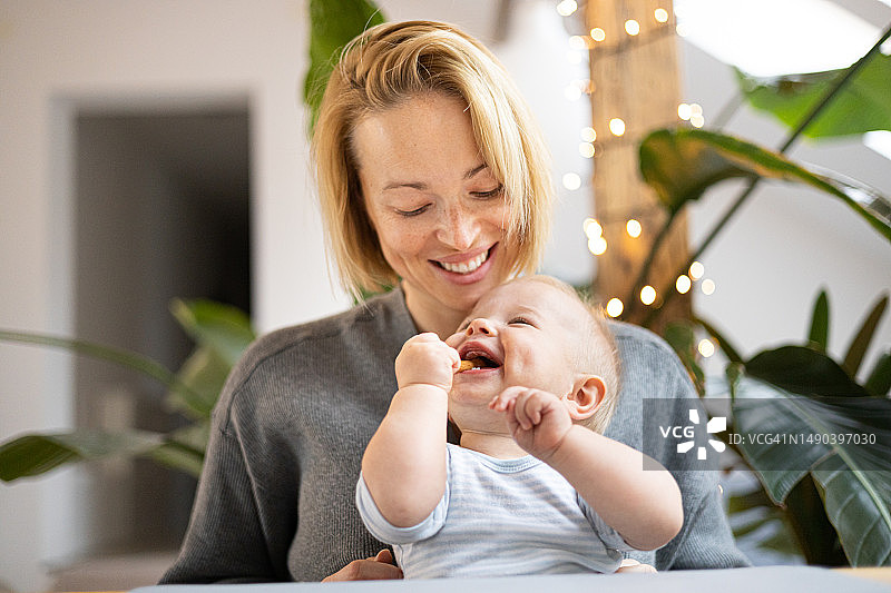 年轻母亲拥抱可爱孩子的肖像图片素材